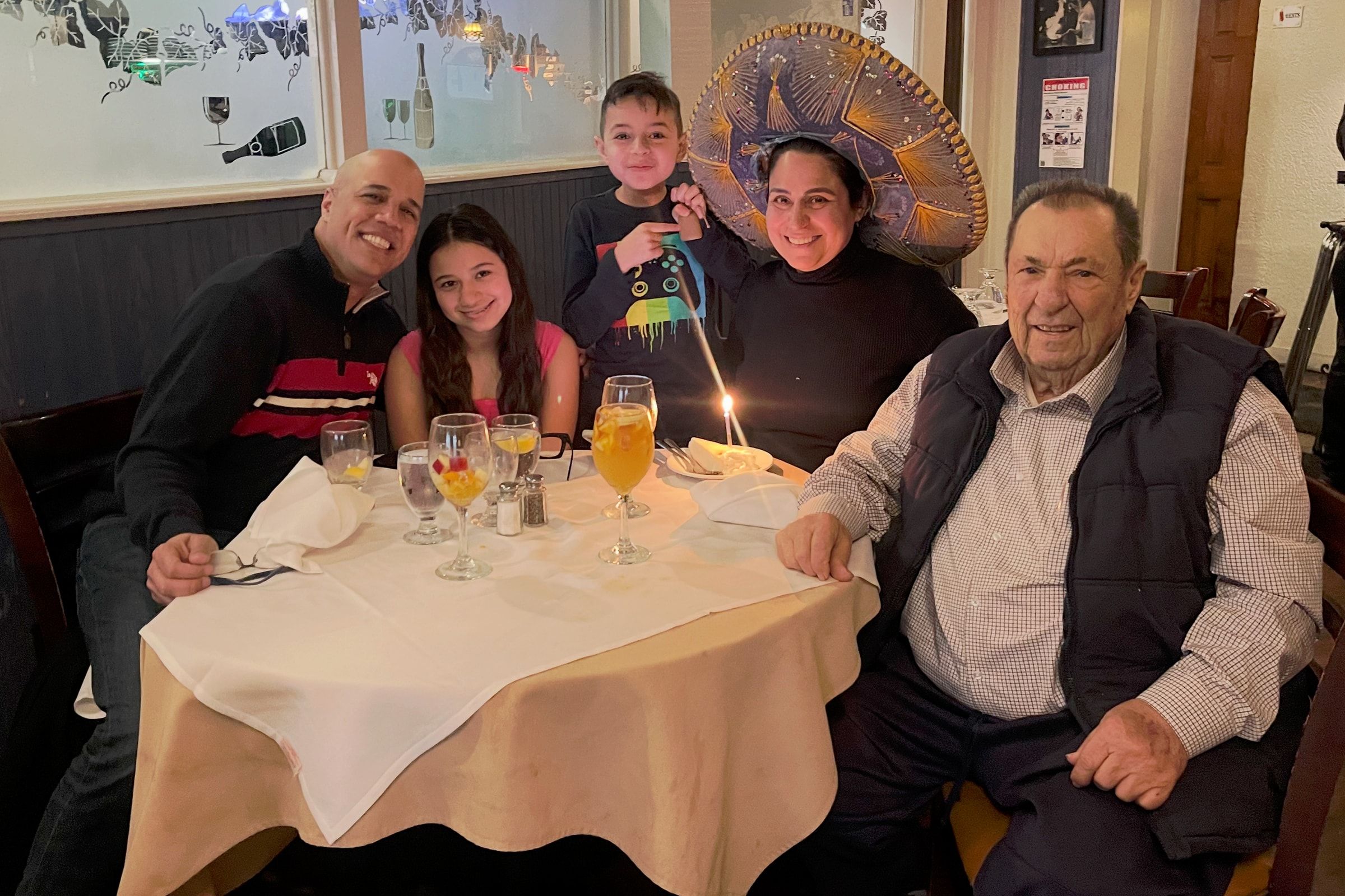 Delia and Luis with family around a table in the Casa Luis dining room